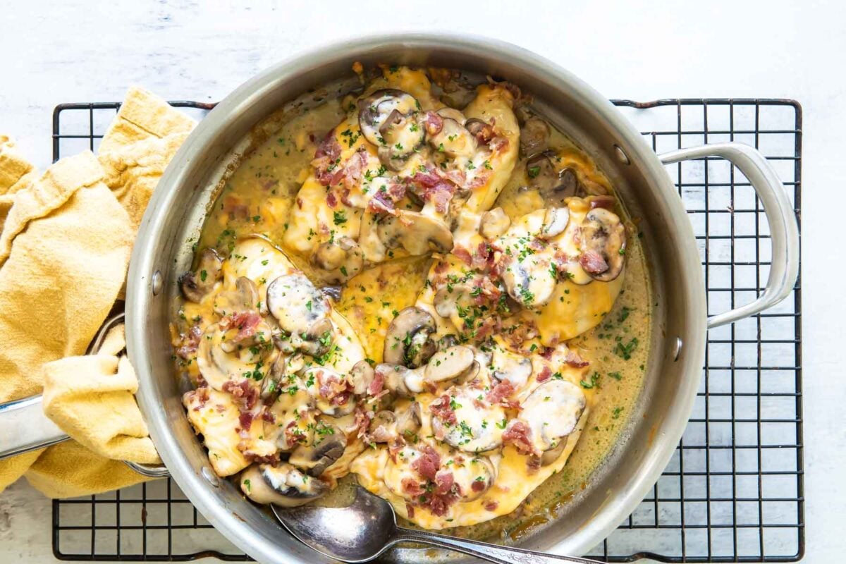Alice springs chicken in a silver pan resting on a cooling rack.