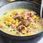 Corn chowder in a dark gray bowl.