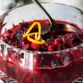 Cranberry sauce in a clear glass decorative bowl.