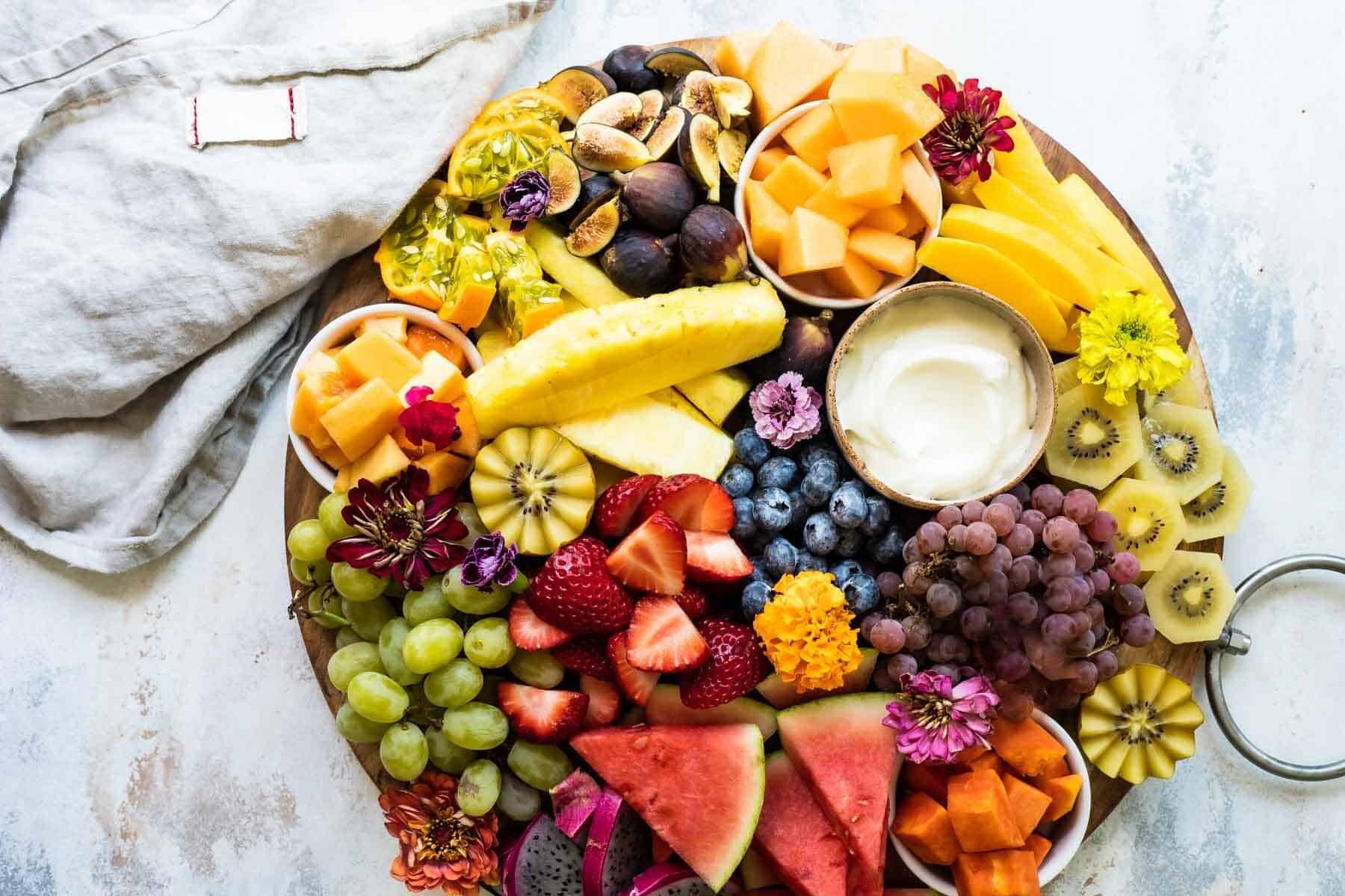 A platter of fresh fruit with fruit dip.