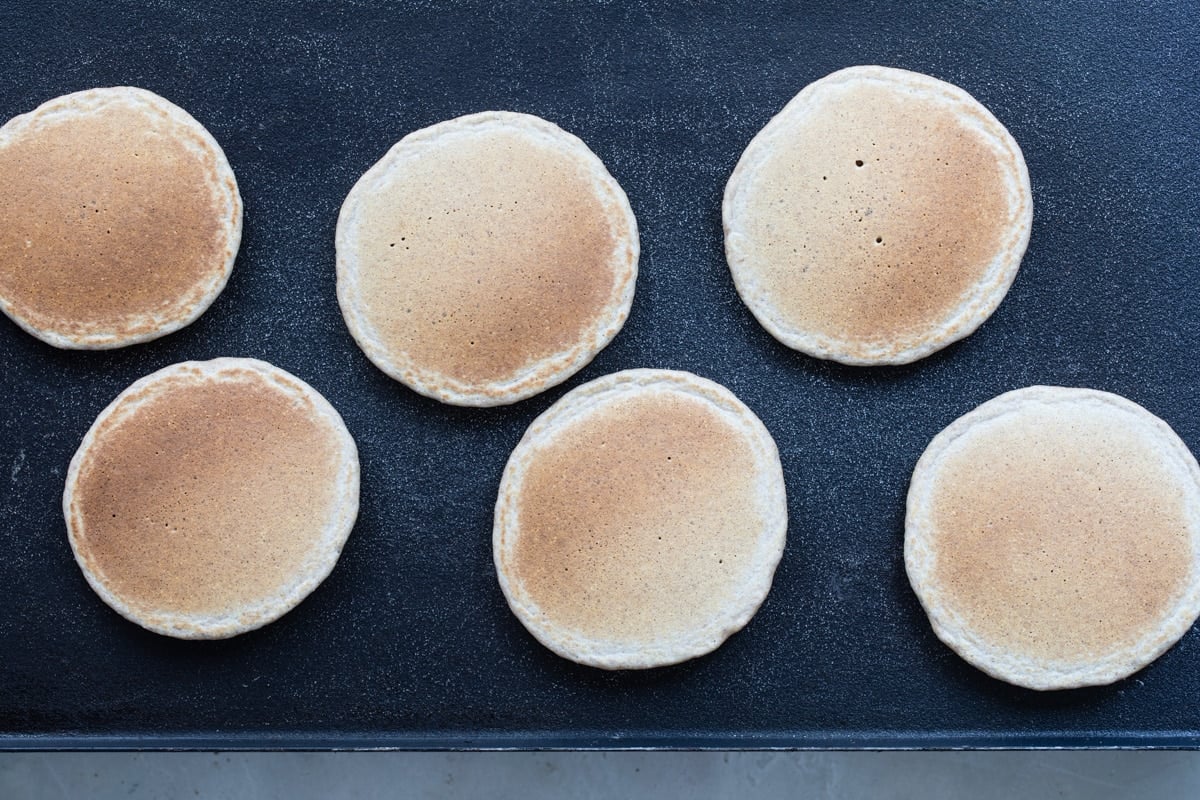 Healthy pancakes on a skillet after flipping.