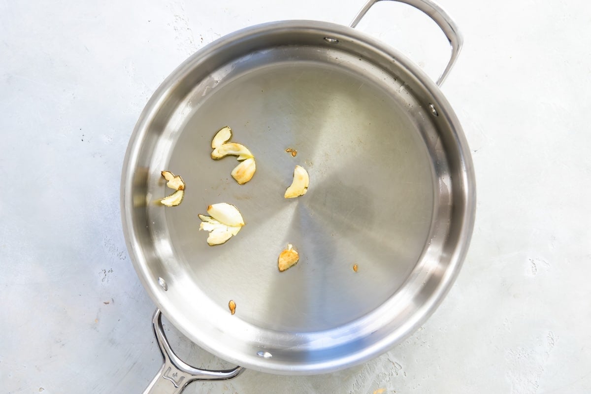 Browning smashed garlic in olive oil.