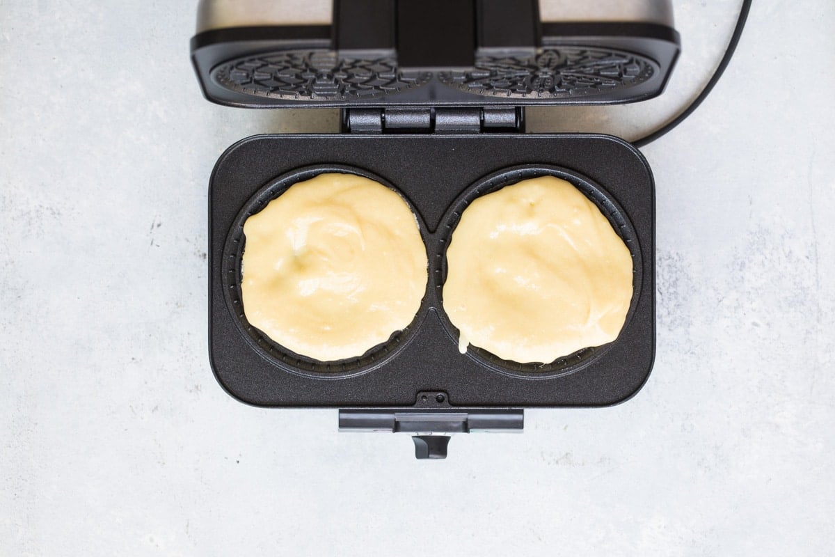Pizzele batter in a pizzele maker.