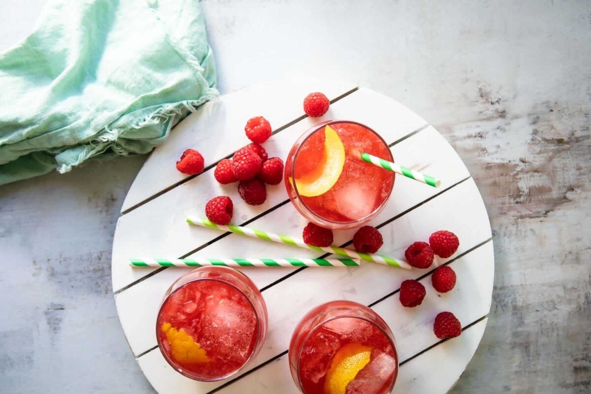 Glass of Raspberry Lemonade Fizz on a white board.