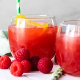Glass of Raspberry Lemonade Fizz on a white board.
