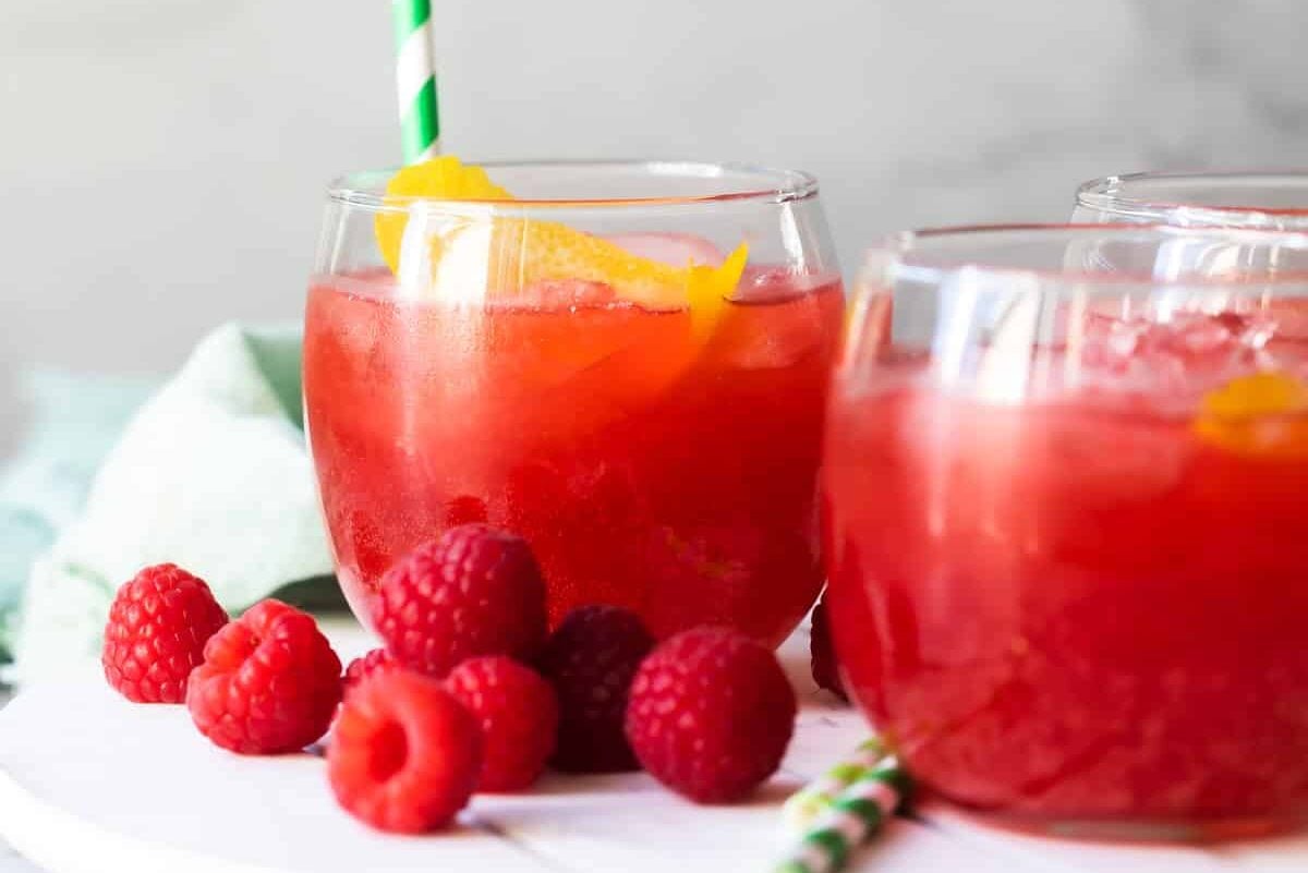 Glass of Raspberry Lemonade Fizz on a white board.