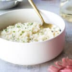 Risotto in a white bowl with a gold spoon.