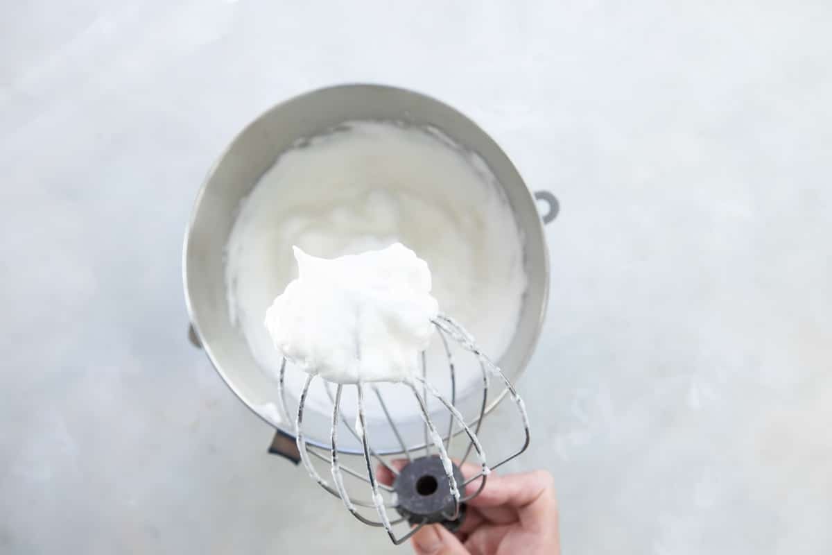 Schaum torte mixture after being whipped in a silver mixing bowl.