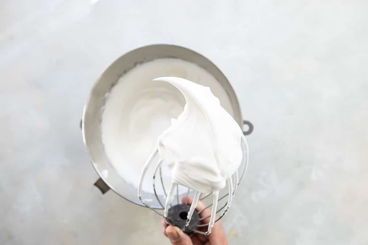 Schaum torte mixture after being whipped in a silver mixing bowl.
