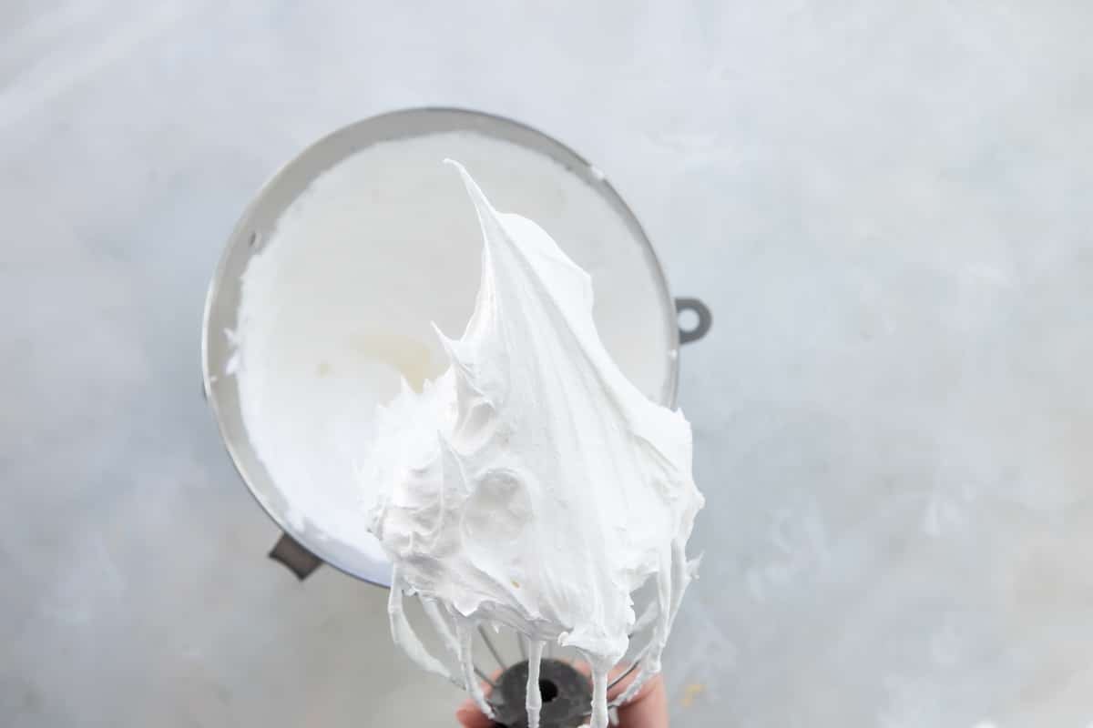 Schaum torte mixture after being whipped in a silver mixing bowl.