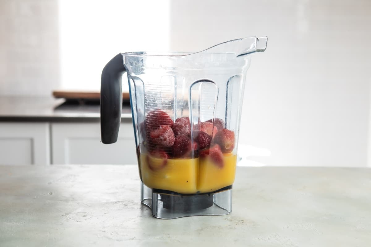 The ingredients for Strawberry Citrus Ginger smoothie in a blender, unblended.