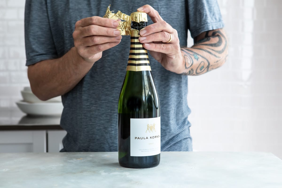Removing foil from a bottle of champagne.