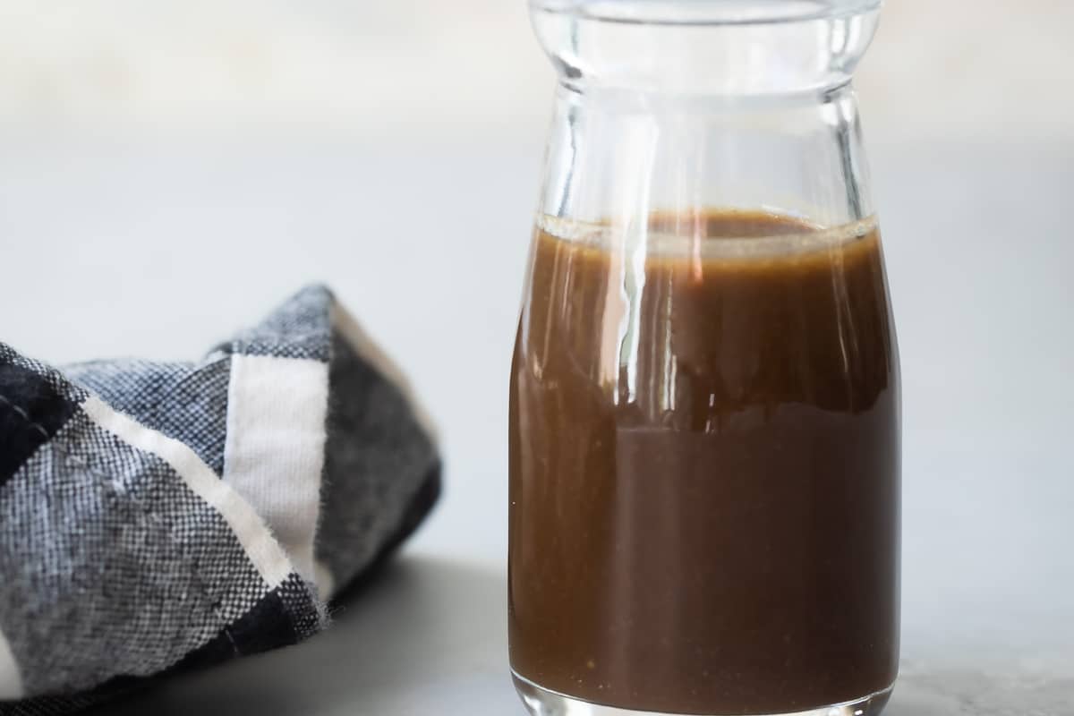 A small bottle filled with balsamic vinaigrette.