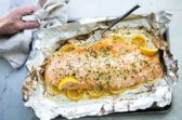 Baked salmon on a foil lined baking sheet after being baked,
