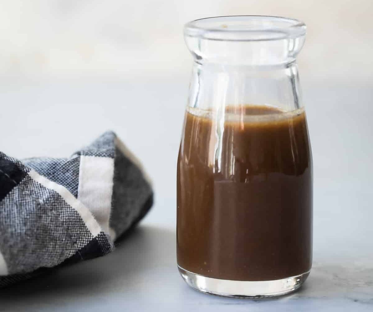 A small bottle filled with balsamic vinaigrette.