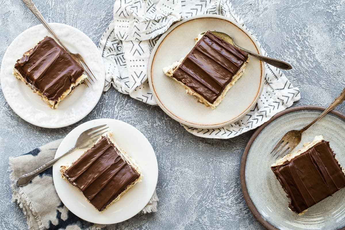 Four slices of chocolate eclair cake on plates.