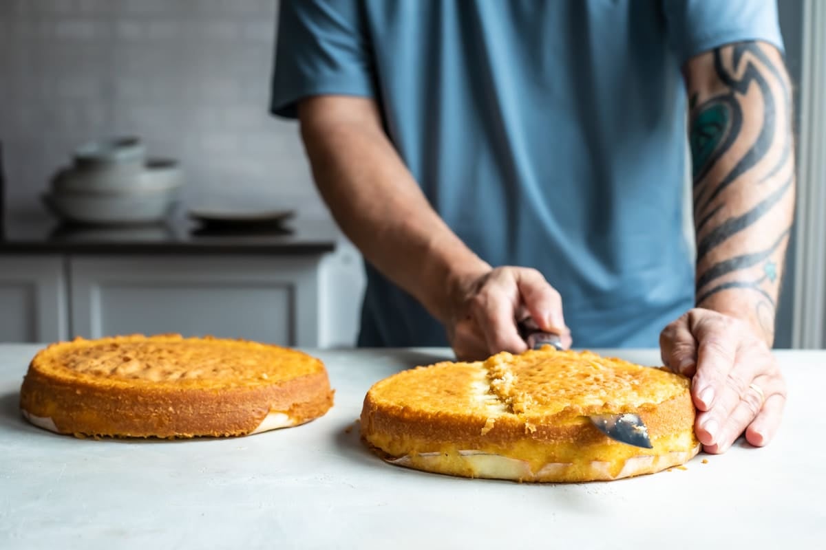 Slicing the dome off a vanilla cake to make it level.
