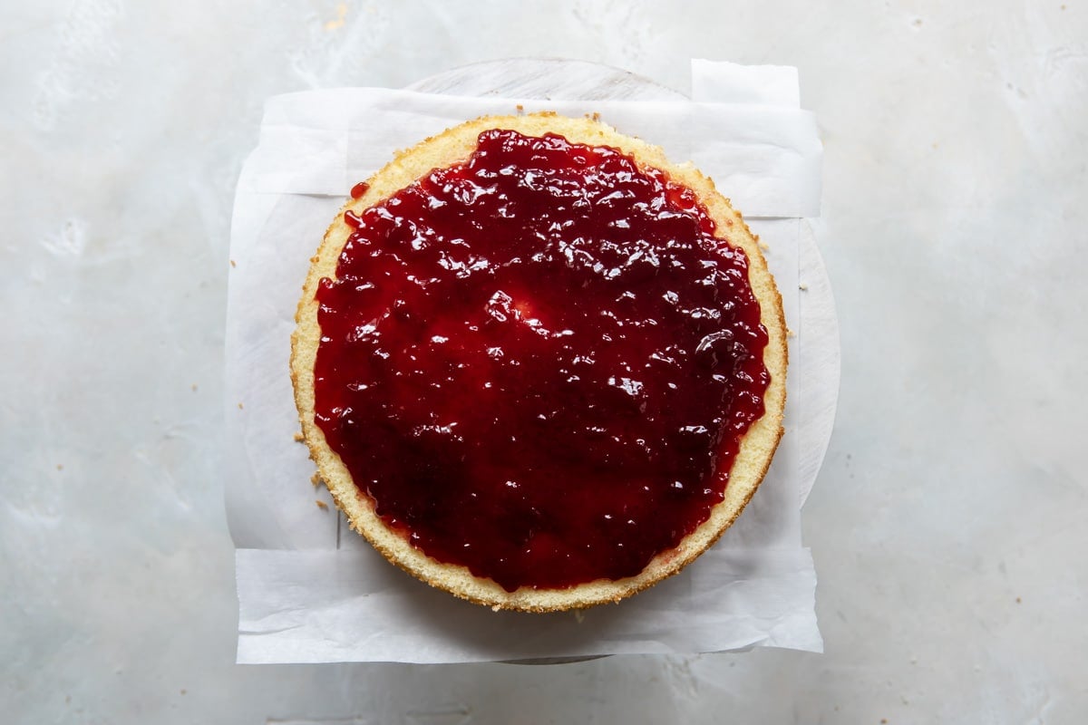 Raspberry jam spread over a layer of cake.
