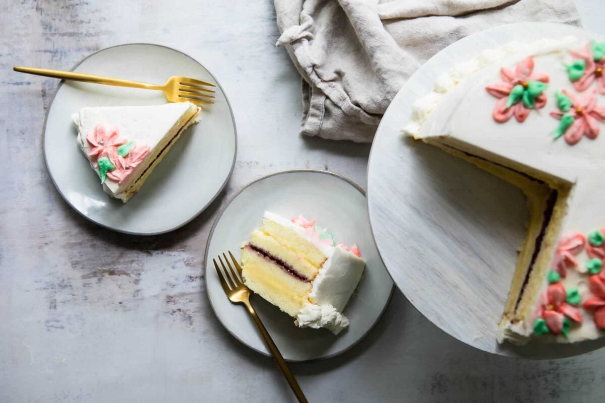 A cut Danish Layer Cake with slices on plates nearby.