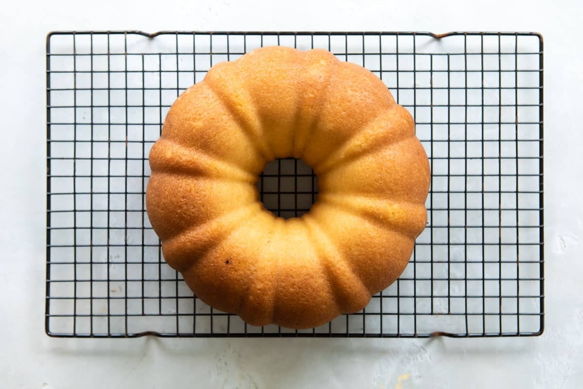 A hot milk cake on a cooling rack.