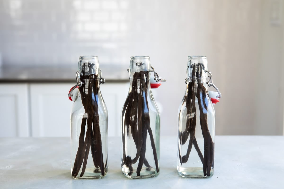 3 bottles with vanilla beans and vodka inside.