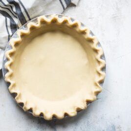 An unbaked pie crust with a fluted edge.