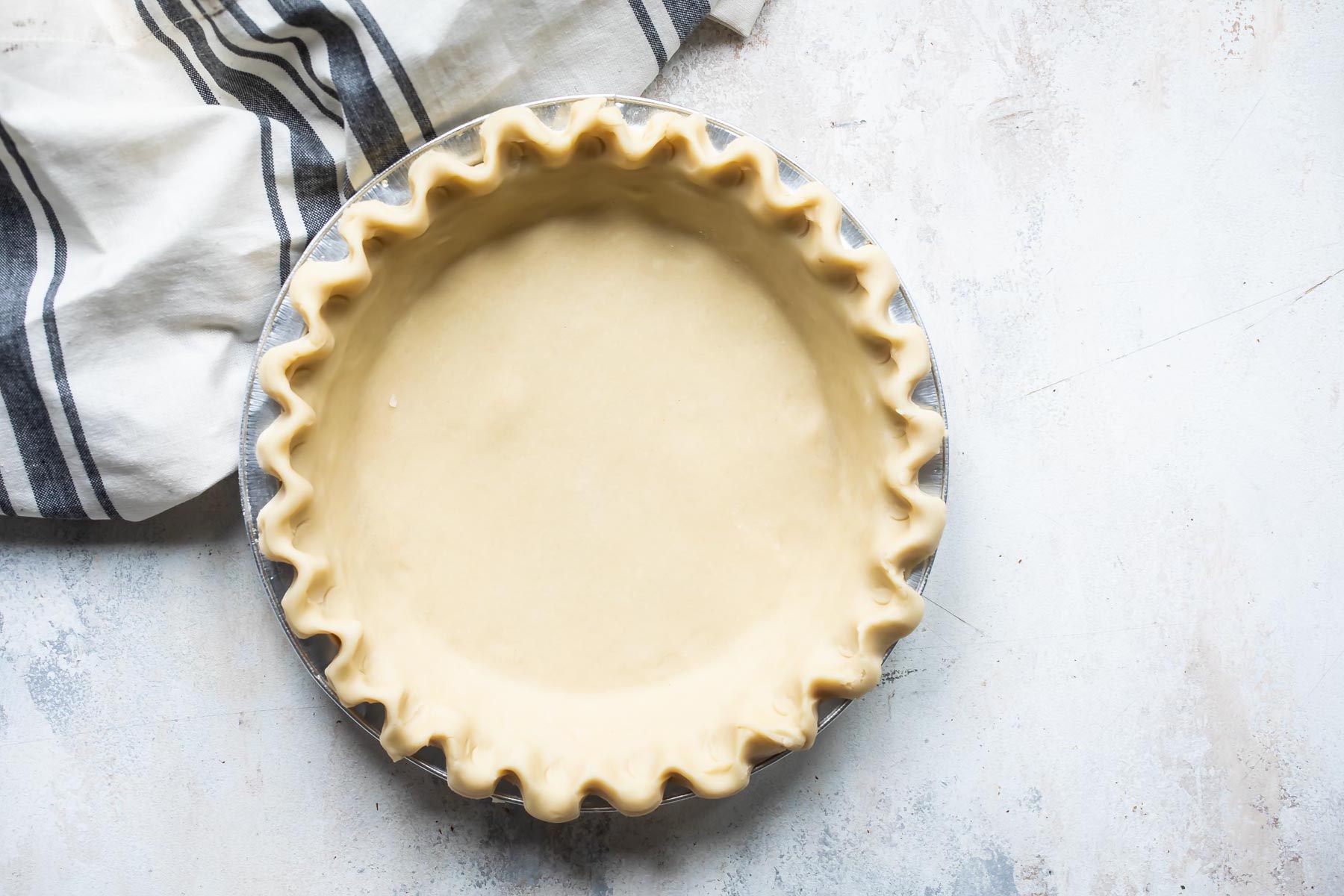 An unbaked pie crust with a fluted edge.