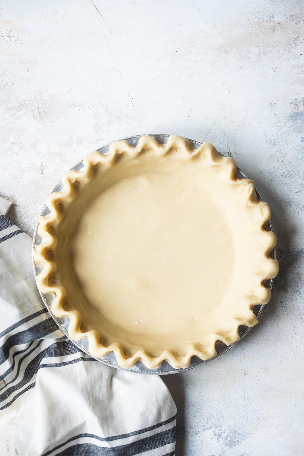 An unbaked pie crust with a fluted edge.