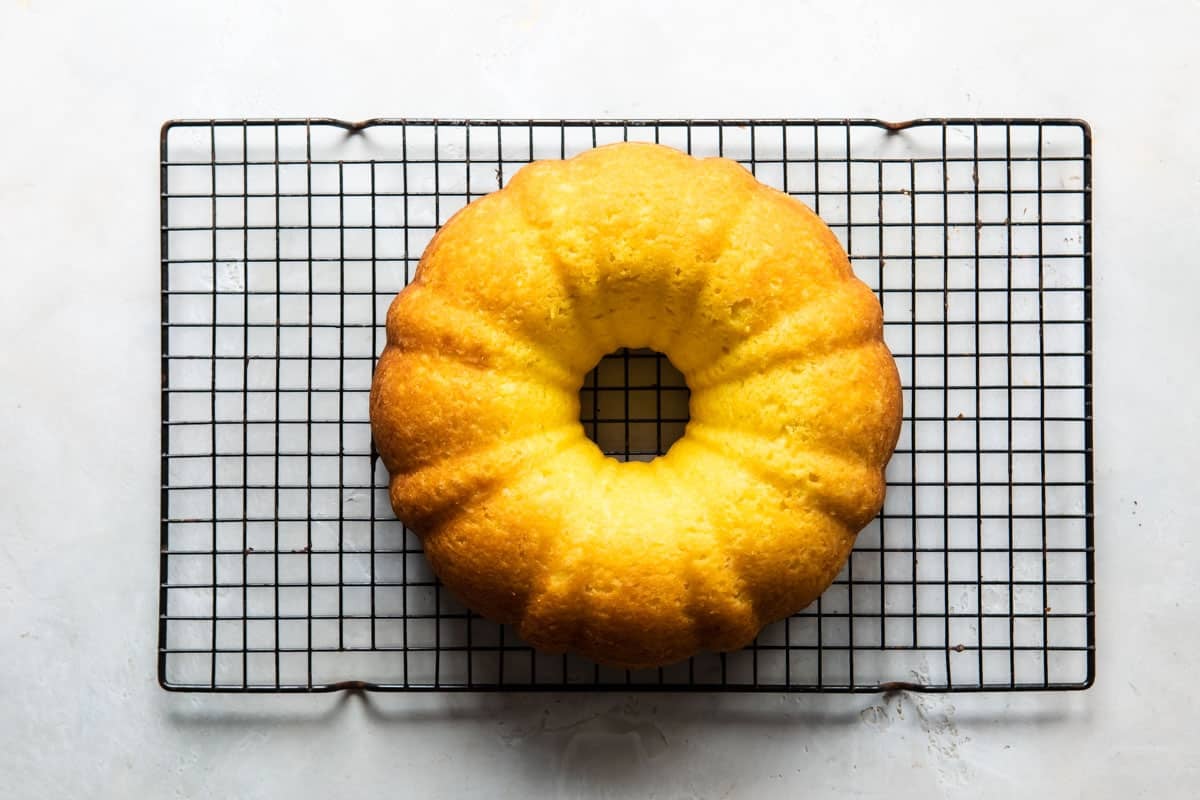 A bundt pan cooling on a baking rack.