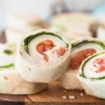 Slices of turkey roll ups on a wooden board.