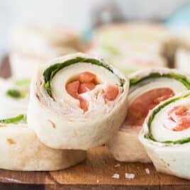 Slices of turkey roll ups on a wooden board.