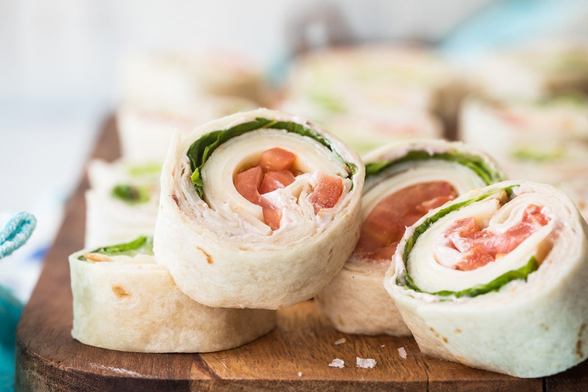 Slices of turkey roll ups on a wooden board.