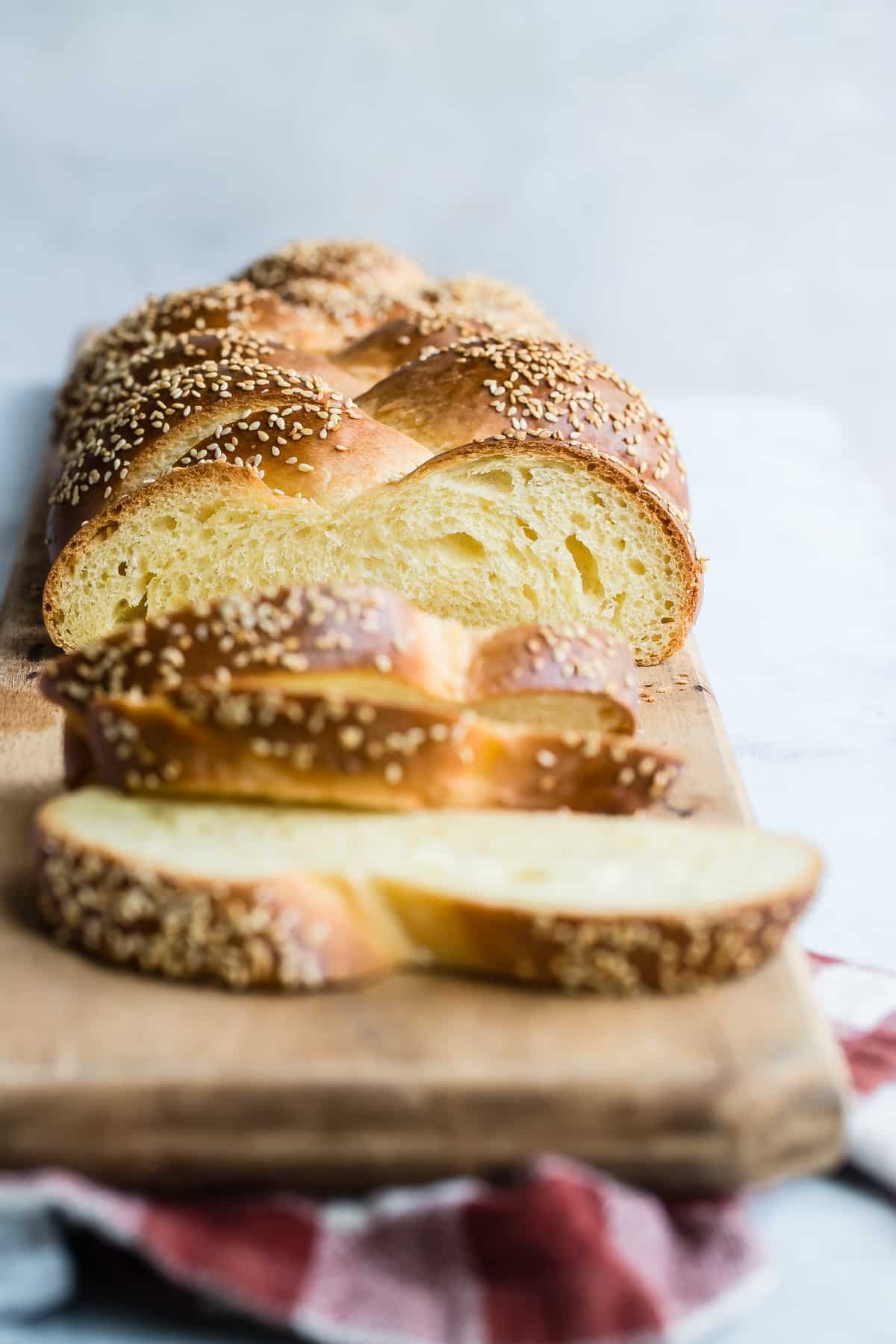 Challah slices on a wood cutting board.