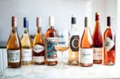 Several bottles of rose wine lined up next to each other.