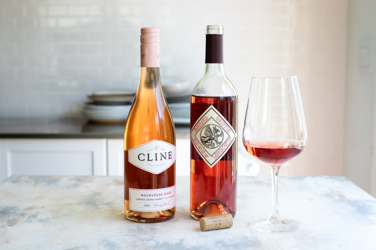 Two bottles of rose wine lined up next to each other.