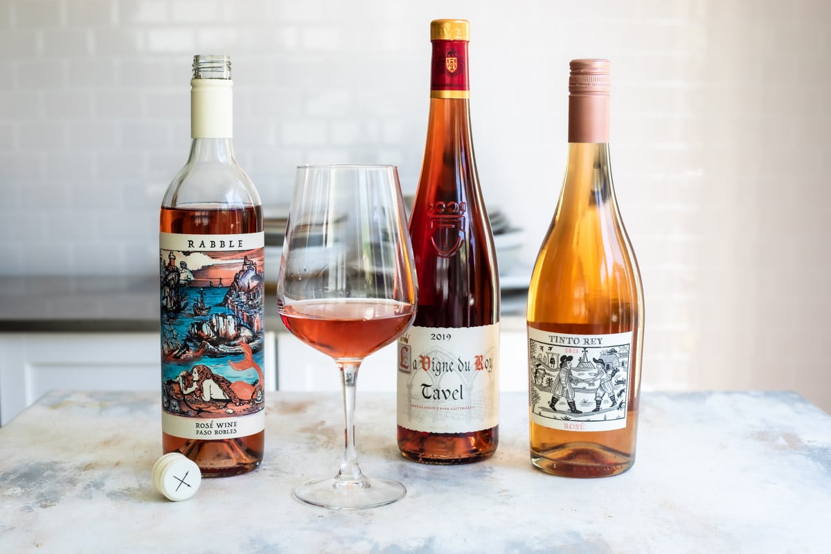 Three bottles of rose wine lined up next to each other.