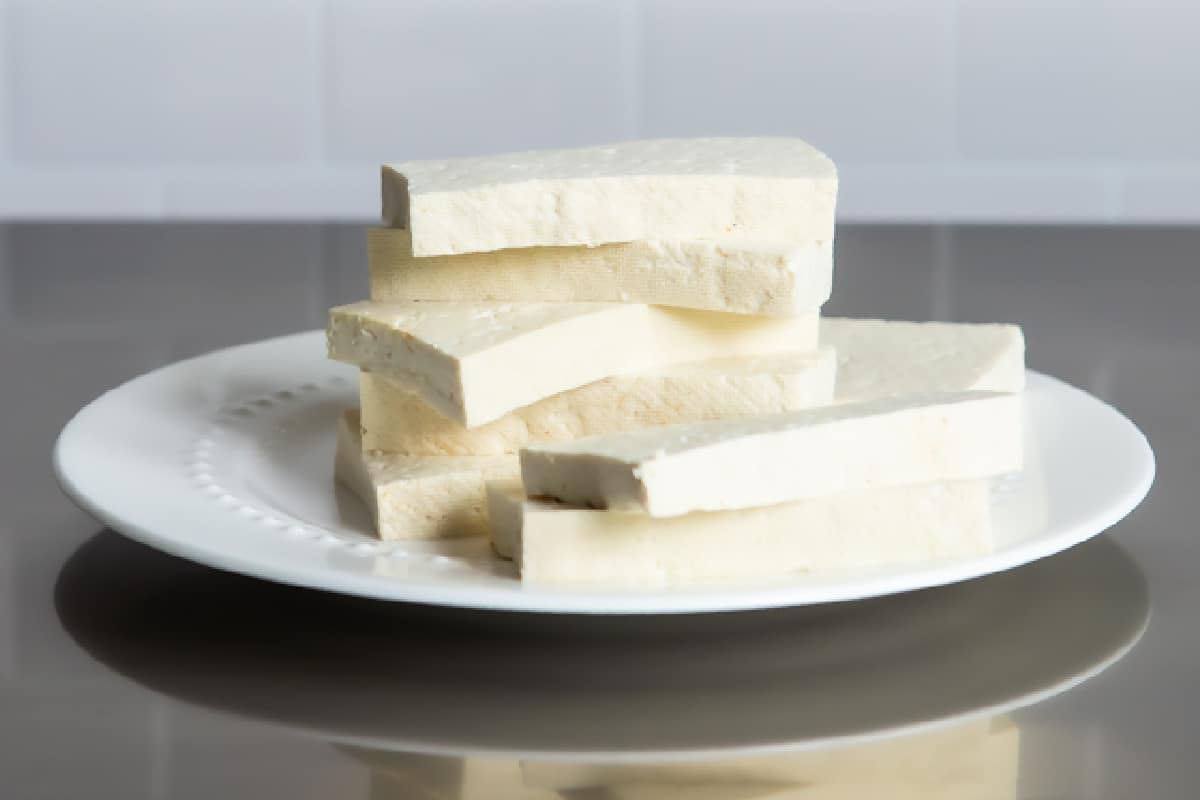 Slices of tofu on a white plate.