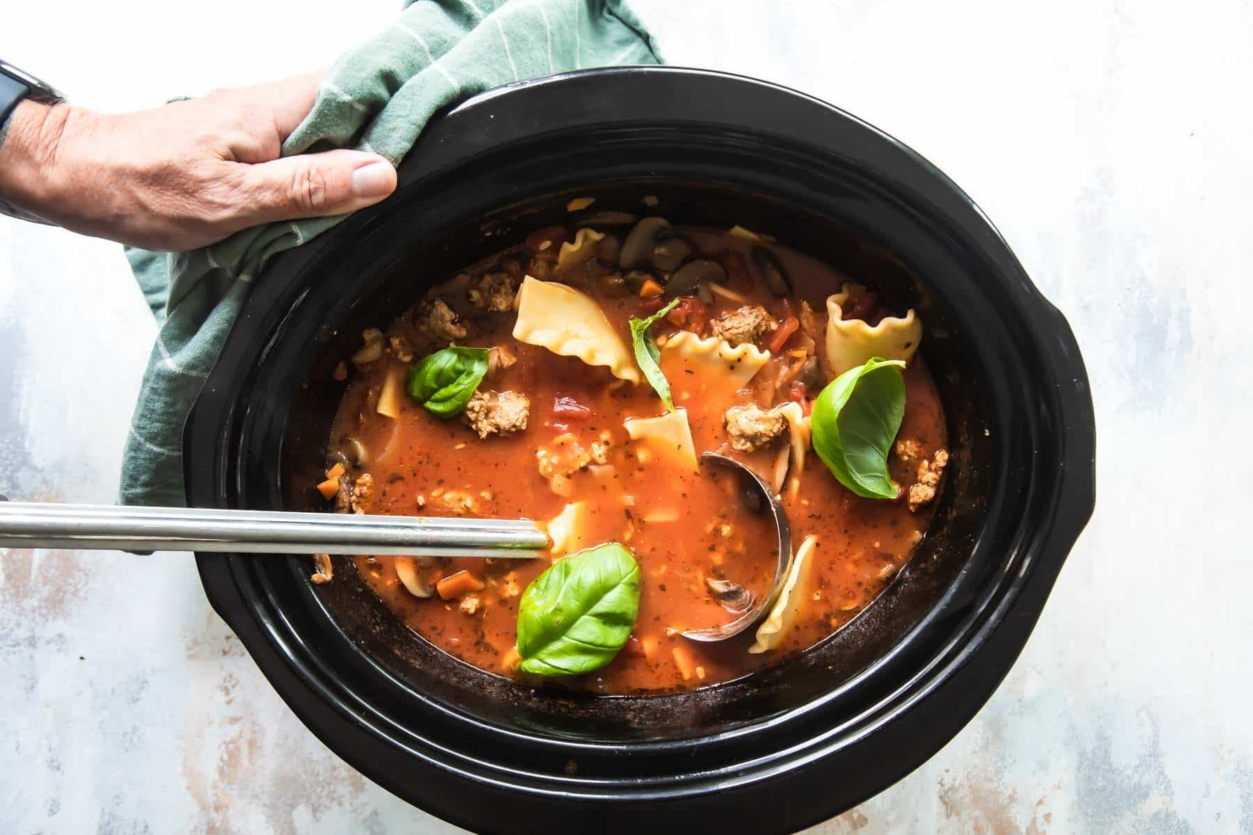 Slow cooker lasagna soup in a black slow cooker.
