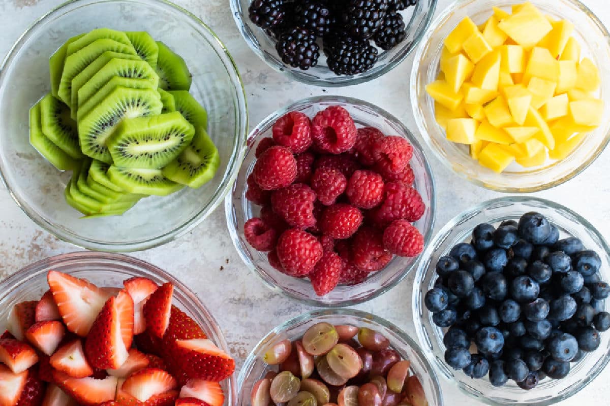 Bowls of fresh fruit on a white background.