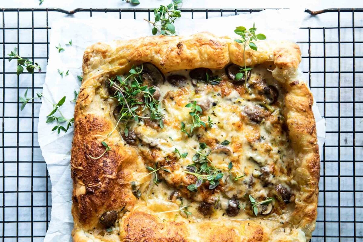 A mushroom and leek tart strewn with fresh thyme.