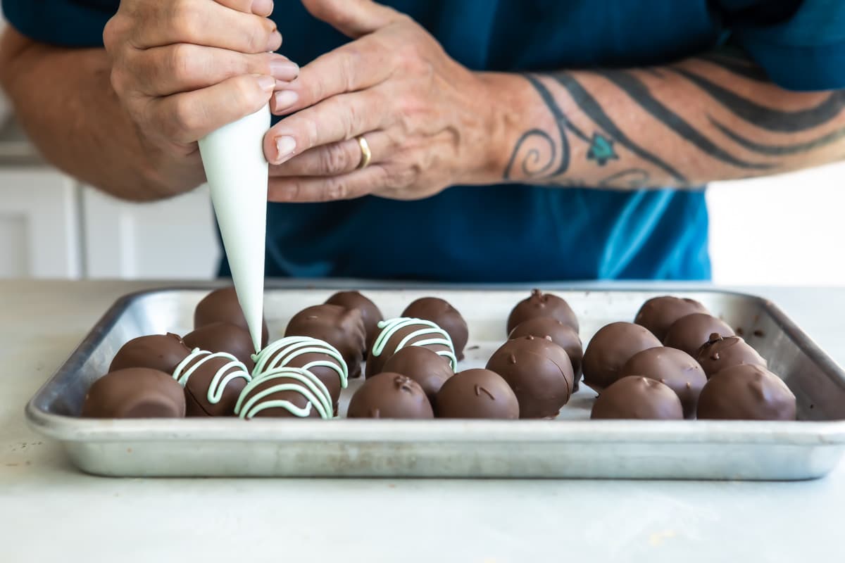 Adding mint drizzle to oreo mint truffles.