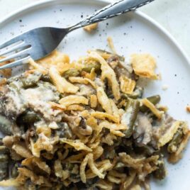 Vegan green bean casserole on a plate with a fork.