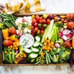 Someone setting down a veggie platter on a countertop.