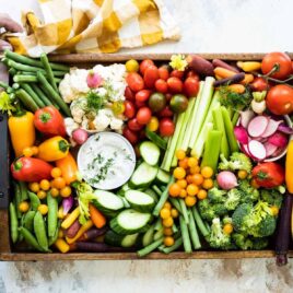 Someone setting down a veggie platter on a countertop.