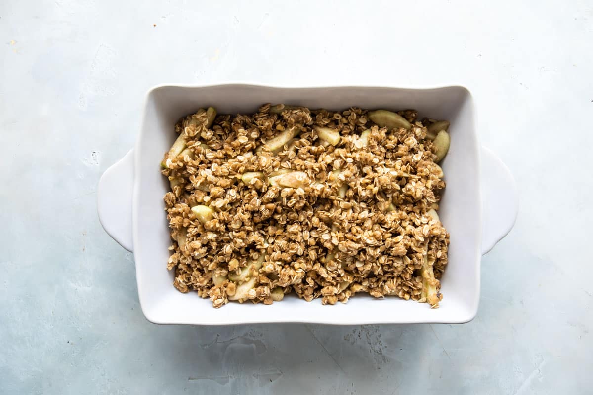 A baking pan full of apple crisp (unbaked).