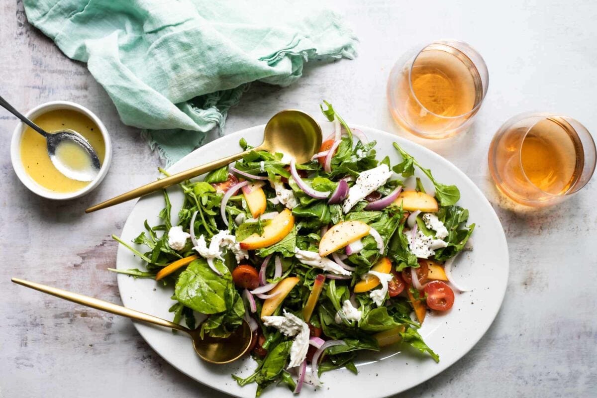 A platter of burrata salad with peaches.