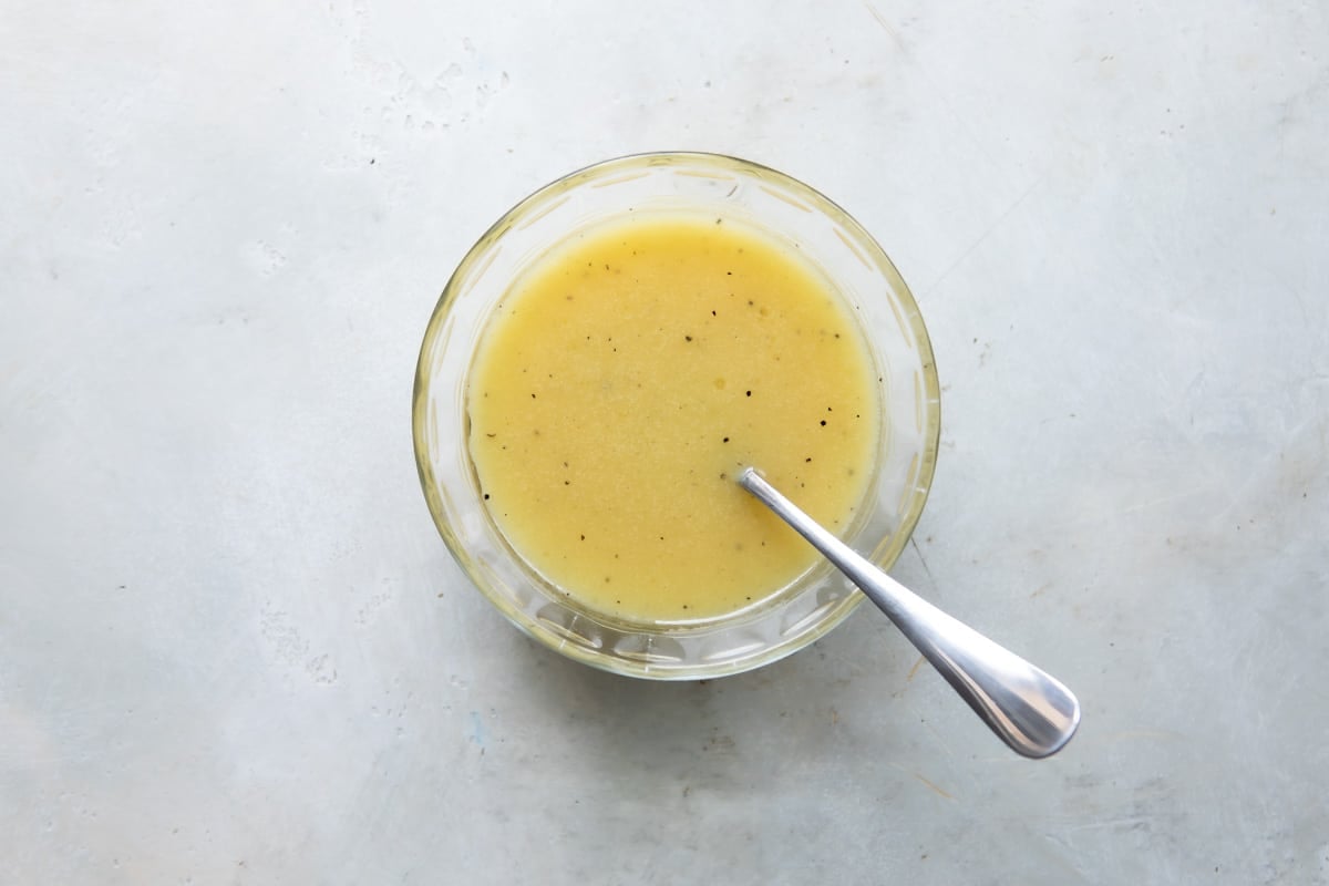 A clear glass bowl full of white wine vinaigrette.