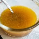 A small clear bowl with fruit dressing in it.