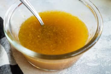 A small clear bowl with fruit dressing in it.
