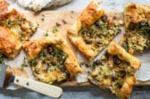 Slices of mushroom and leek tart strewn with fresh thyme.